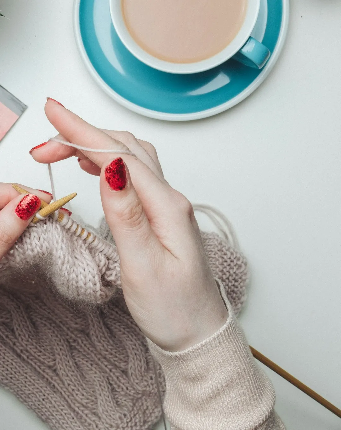 Knitting a cable jumper beside a cup of tea